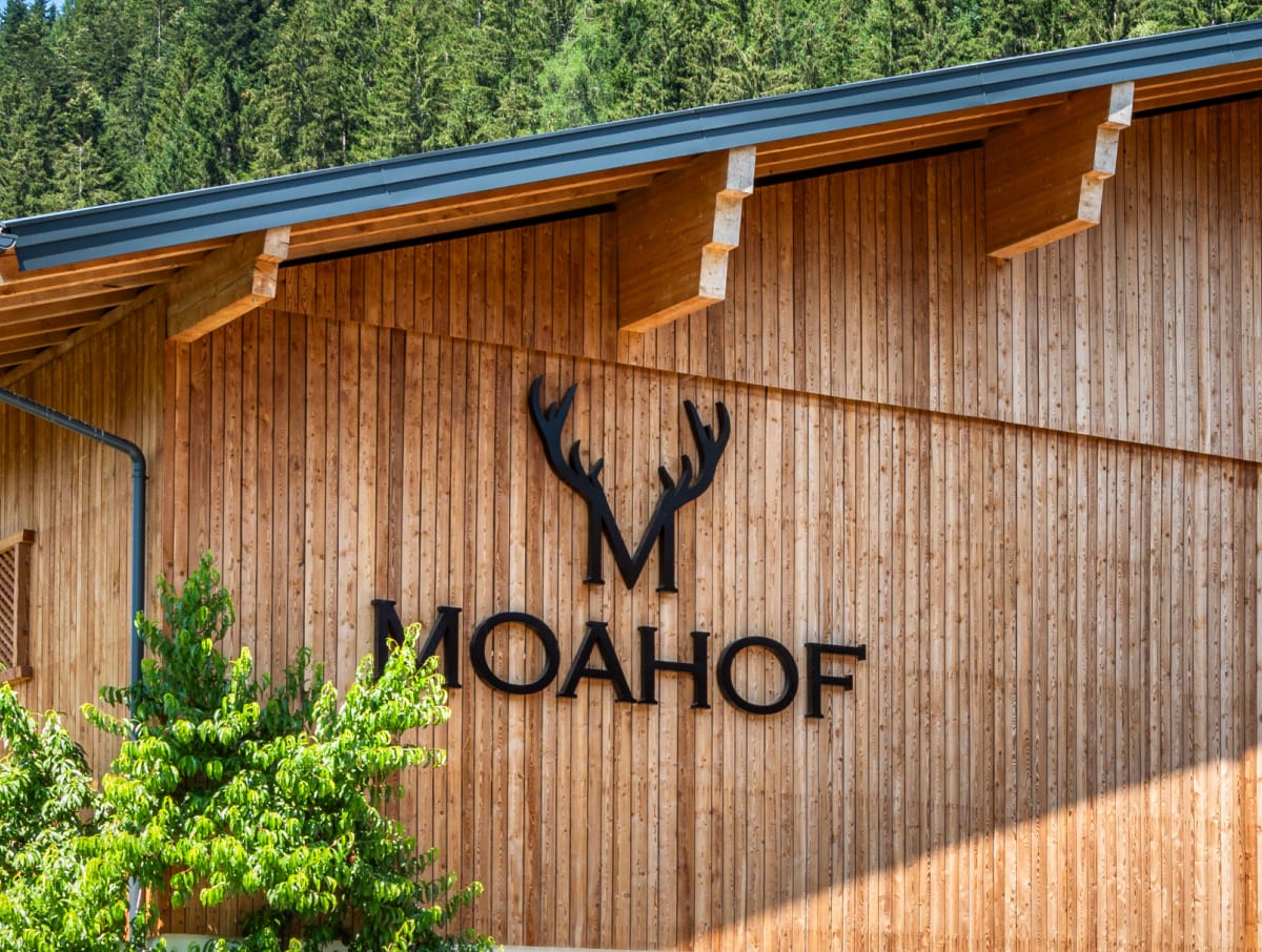 Au&szlig;enfassade aus Holz am Moahof in Werfenweng mit Logo-Beschriftung.